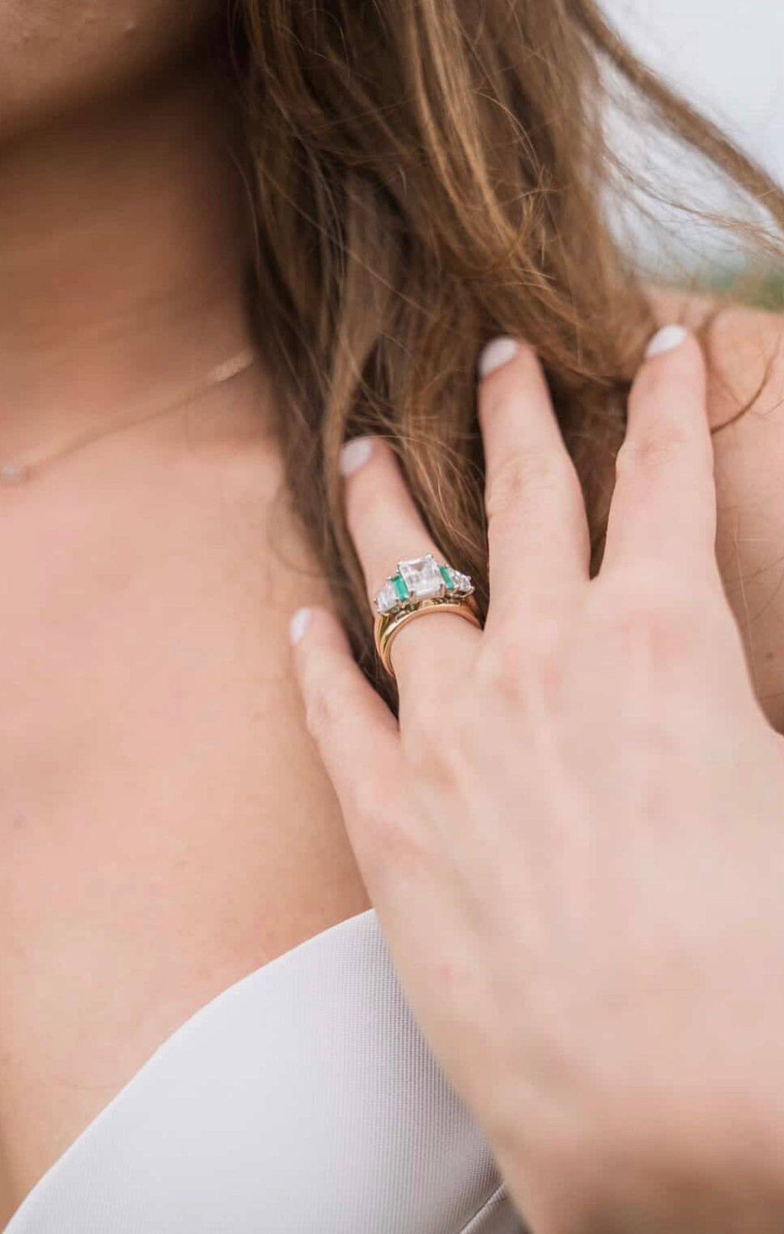 A halo diamond engagement ring from Homsy Jewelers worn at an evening celebration
