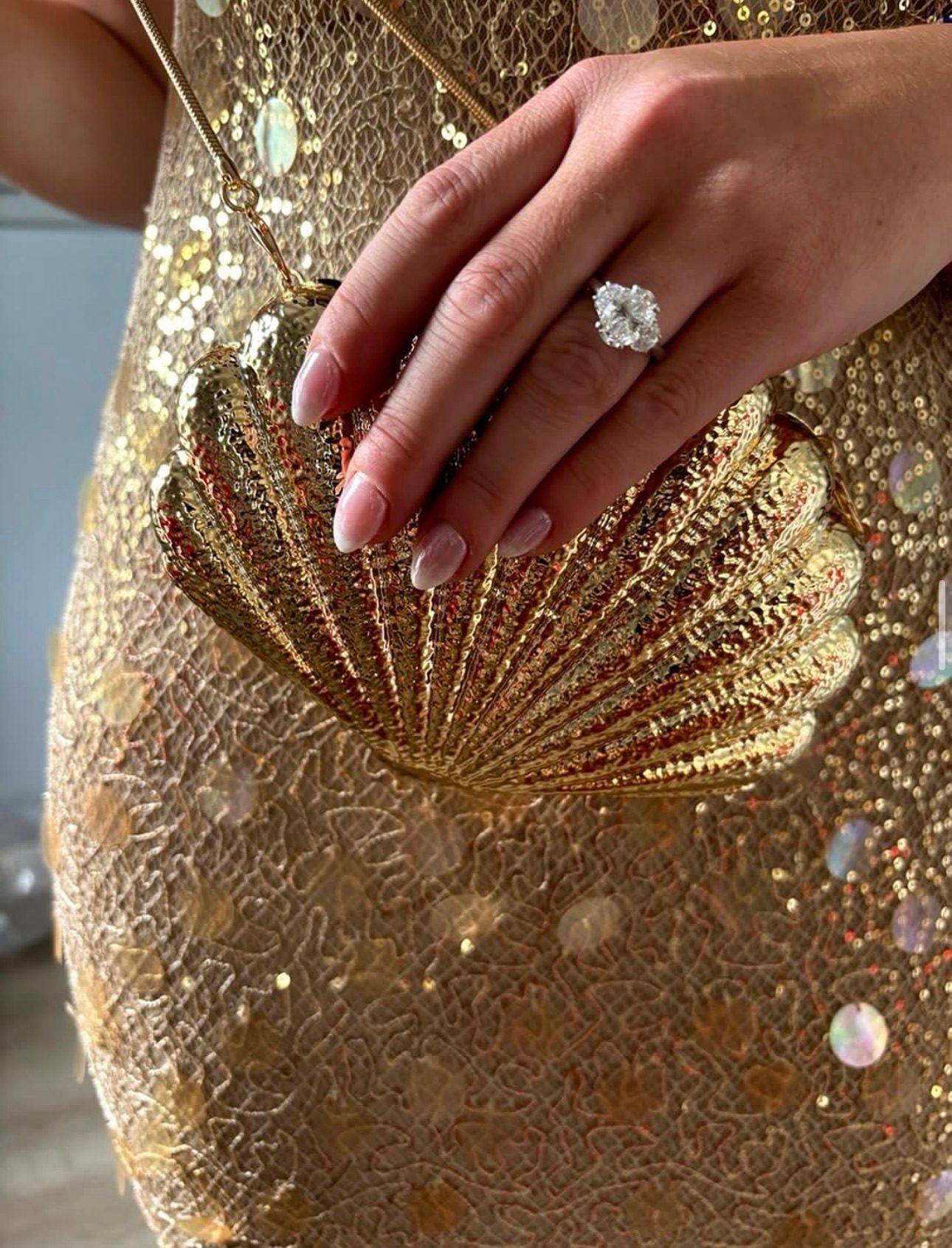 An oval diamond engagement ring from Homsy Jewelers worn with an evening dress