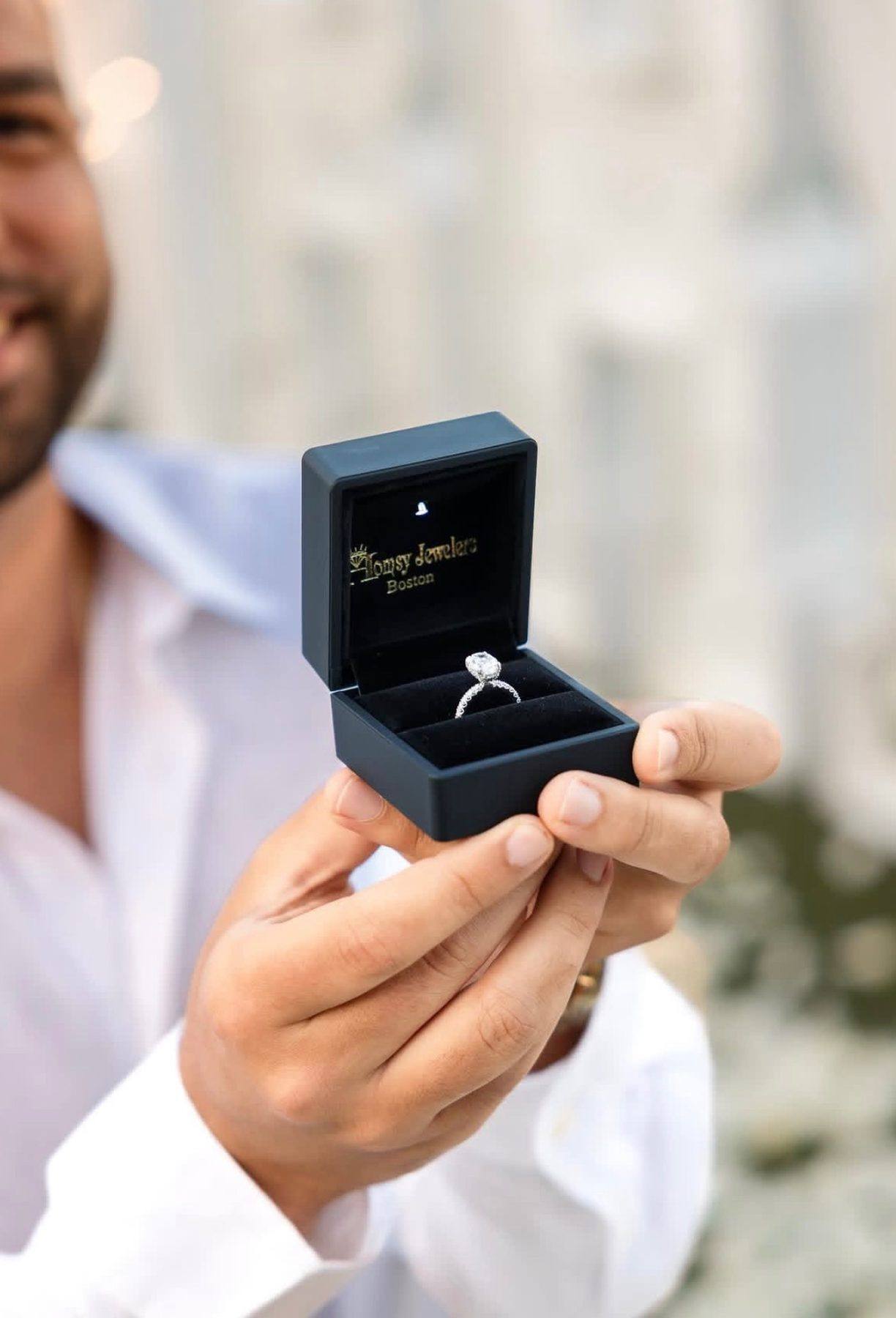 A diamond engagement ring presented in a Homsy Jewelers Boston ring box